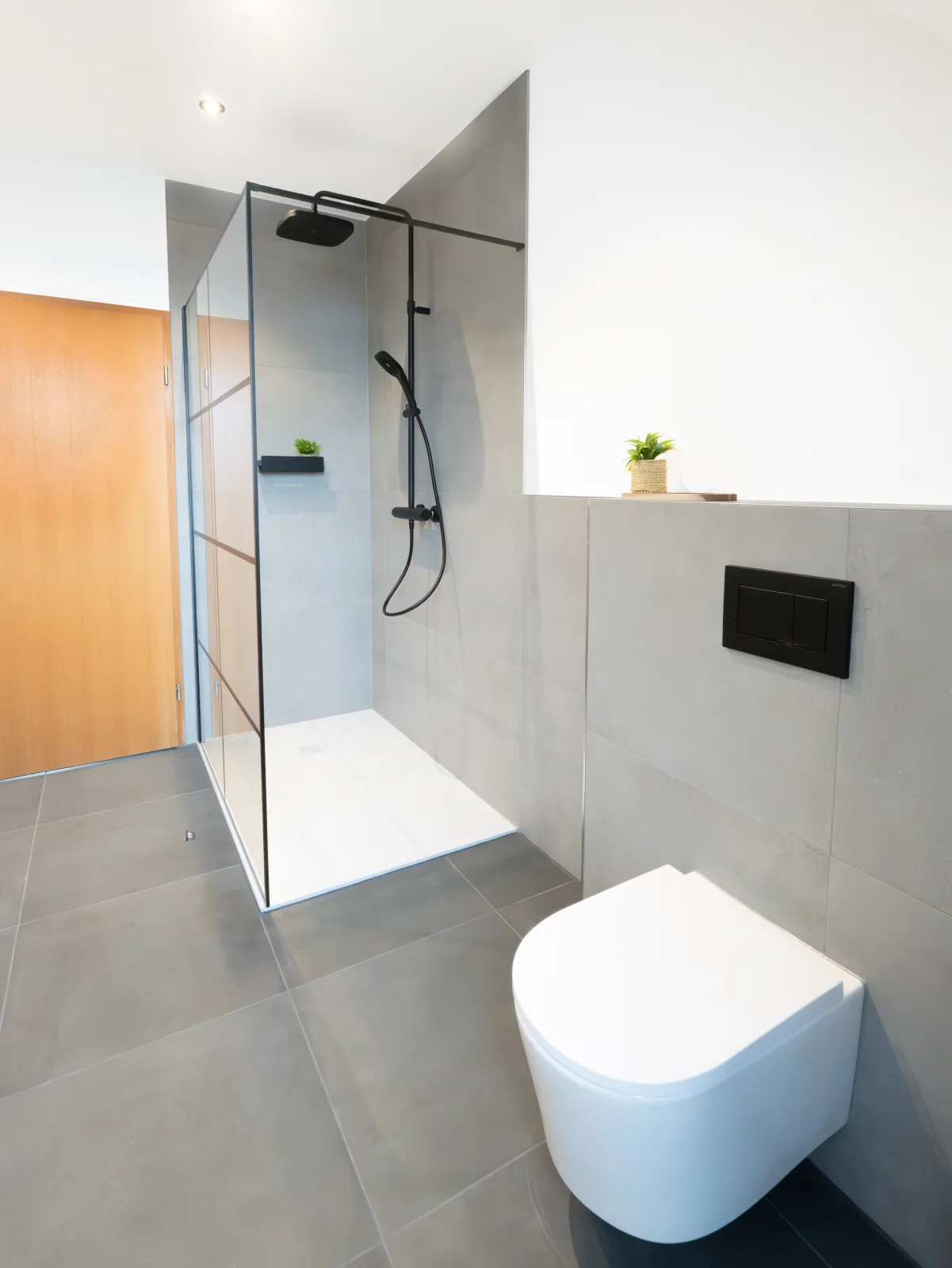 Modernes Bad in Grau mit Dusche, WC und schwarzen Armaturen – Fliesenleger Erlangen Meisterbetrieb Jan Dimov