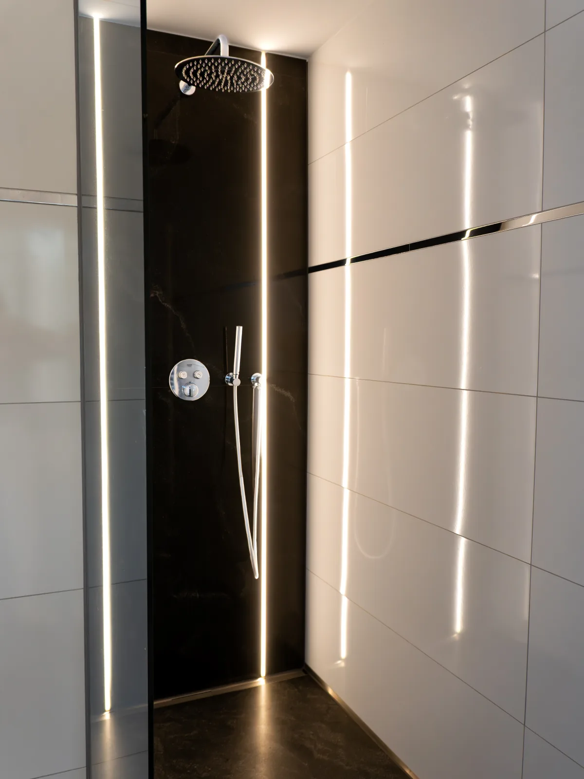 Dusche mit schwarzer Steinwand und weißen Fliesen – Fliesenleger Erlangen Meisterbetrieb Jan Dimov